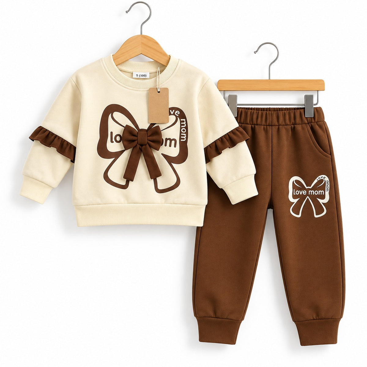Cream sweatshirt with brown ribbon bow and sleeve ruffles beside matching brown Love Mom bow-print joggers
