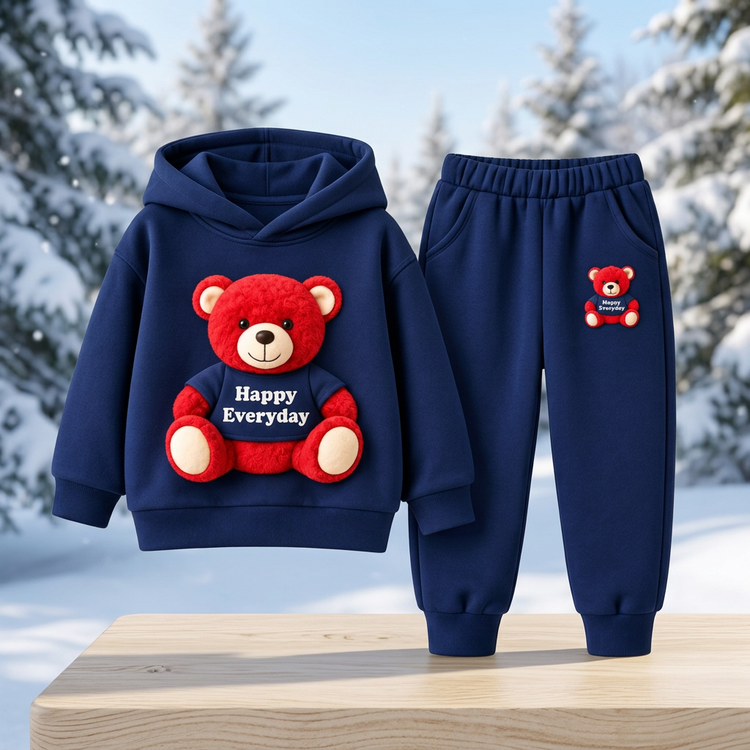 Children’s navy teddy-bear hoodie and matching joggers displayed in a snowy woodland catalog setting