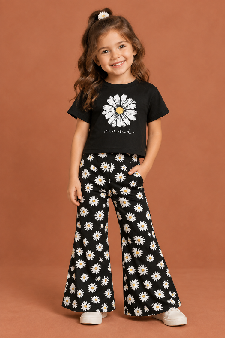 Girl model wearing black daisy top and matching daisy flared pants against a terracotta studio background