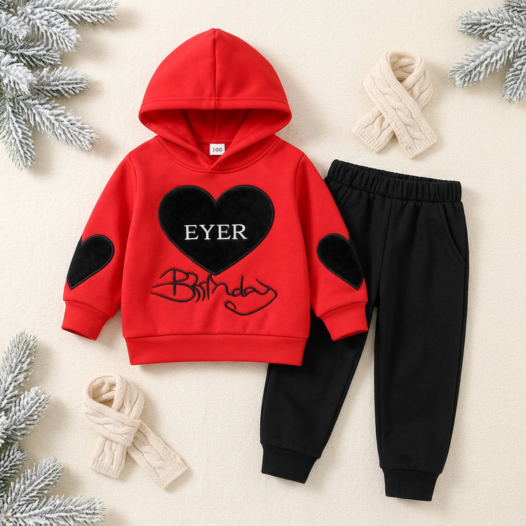 Kids’ red hoodie with black heart details and black jogger trousers on a winter-themed background